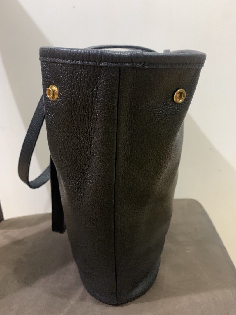 Mornington (Category: Luxury Bags & Wallets) located in Muntinlupa City. Submitted by mabelleadr46801 (Listing ID 1462768339, Image 3). Description: Fibreno Mornington Shopper Bag.This minimalist tote is crafted from textured black pebbled leather and features distinct gold hardware accents, including structural studs flanking the upper opening and a signature circular gold button charm emblazoned with the brand logo centered on the front..