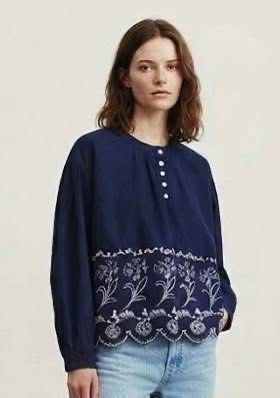 Navy Blue Embroidered Blouse with Button Detail (Category: Blouses) located in Donsol. Submitted by saksthriftavenuebyluckymaria8 (Listing ID 1462880197, Image 1). Description: - Navy blue long-sleeved blouse - White floral embroidery along the hem - Scalloped hem edge - Round neckline with button-up placket - Balloon sleeves - Versatile: pairs well with jeans or skirts - Comfortable and stylish for everyday wear Navy blue Floral Hem Blouse featu