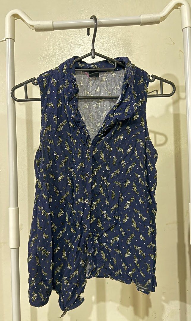 Navy Blue Floral Sleeveless Button-Up Blouse (Category: Blouses) located in Manila. Submitted by lovedbyan (Listing ID 1462878344, Image 1). Description: -S - Navy blue sleeveless blouse - Delicate white and green floral print - Collared neckline - Button-up front - Ideal for casual wear or layering.