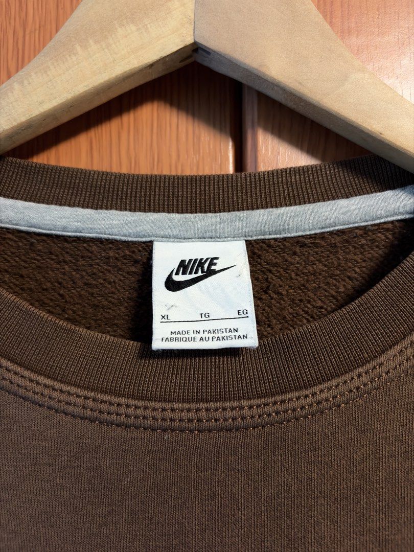 Nike Brown Crewneck Sweatshirt XL (Category: Coats, Jackets and Outerwear) located in Caloocan City. Submitted by puremountain.2e6573 (Listing ID 1462860167, Image 3). Description: - Brown Nike sweatshirt - Small white swoosh logo on chest - Tagged size XL - Made in Pakistan - Ideal for casual wear - Please check photos for condition details.