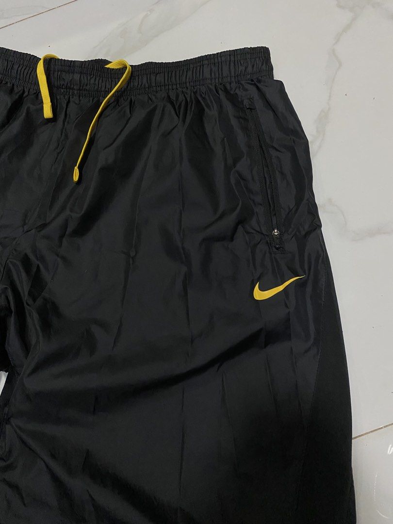 Nike Live Strong Track Pants Black Yellow (Category: Joggers) located in Taguig. Submitted by jhayarpuen15676 (Listing ID 1462775897, Image 2). Description: - Black Nike track pants - Yellow accent details - Drawstring waist for adjustable fit - Zippered pockets for secure storage - "Live Strong" logo prominently displayed - Zippers along the legs for customizable fit - Ideal for athletic activities or everyday casual style - Waistline 32-46 - Le