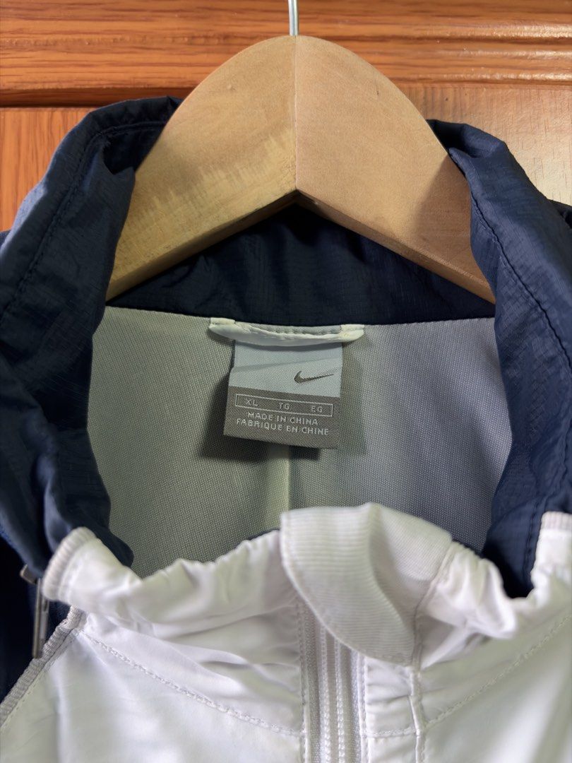 Nike Windbreaker Jacket Navy White XL (Category: Coats, Jackets and Outerwear) located in Caloocan City. Submitted by puremountain.2e6573 (Listing ID 1462860049, Image 3). Description: - Brand: Nike - Type: Windbreaker Jacket - Size: XL - Color: Navy Blue and White - Features: Hooded, suitable for light rain or wind - Condition: Small mark on the inside of the white panel (refer to last photo) - Origin: Made in China.