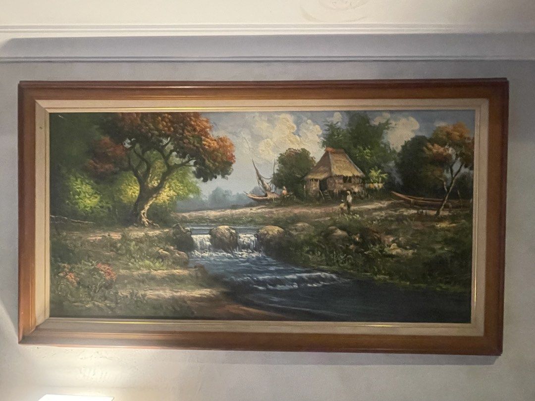 Oil on canvas painting (Category: Frames & Pictures) located in Manila. Submitted by goldenocean_ea7df8 (Listing ID 1462716077, Image 1). Description: A classic pastoral Philippine rural scene featuring a bahay kubo, native boats, a flowing stream with stepping stones, and lush foliage reminiscent of traditional local countryside art. measuring approximately 70 inches across (including the outer frame), making it a substantial statement piece for