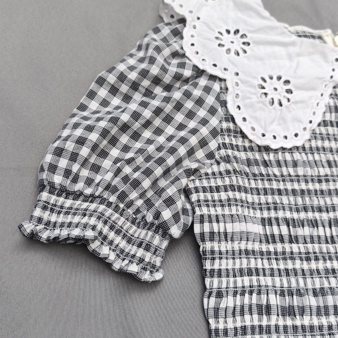 ONLY Black & White Gingham Smocked Top with Eyelet Collar (Category: Blouses) located in Alfonso Lista (Potia). Submitted by ak_collection.03 (Listing ID 1462802452, Image 3). Description: Elevate your wardrobe with this stylish Cottagecore / Coquette aesthetic peplum blouse from ONLY. Features a classic monochrome gingham plaid pattern, an elasticized smocked bodice for a flattering stretchy fit, and a dramatic statement white eyelet lace collar