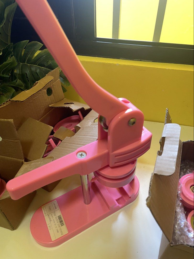 Pink Button Maker Machine with Button Parts (Category: Craft Supplies & Tools) located in Infanta. Submitted by frandez (Listing ID 1462755534, Image 1). Description: - Pink button maker machine - Includes various sizes of button parts (machine, molds, shells, pins) - Ideal for DIY projects and small businesses - Features easy-to-use lever action - All parts are in original packaging Still in good condition.