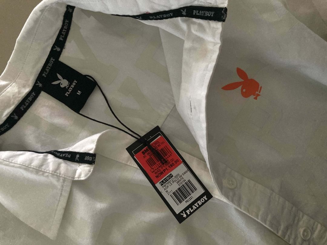Playboy White Button-Up Shirt with Logo Pattern (Category: Tshirts & Polo Shirts ) located in Binan City. Submitted by eiadeia. (Listing ID 1462770380, Image 3). Description: - White Playboy button-up shirt - Subtle all-over Playboy logo pattern - Small orange Playboy bunny logo on chest - Size: Medium (M) - Brand new with tags attached.