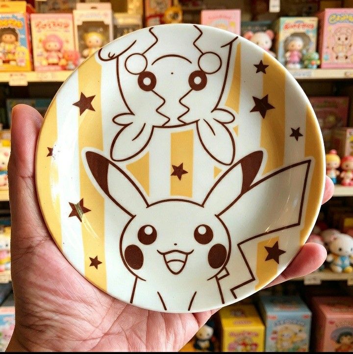 Pokemon Mister Donut Pikachu & Plusle/Minun Plate (Category: Character Goods) located in Iligan City. Submitted by sariranaw (Listing ID 1462881715, Image 1). Description: - Adorable Pokemon plate featuring Pikachu and either Plusle or Minun. - Unique Mister Donut collaboration design. - Features a fun yellow and white striped background with brown stars. - Ideal for serving snacks or as a small trinket dish. - Approximately 4-5 inches in diamete