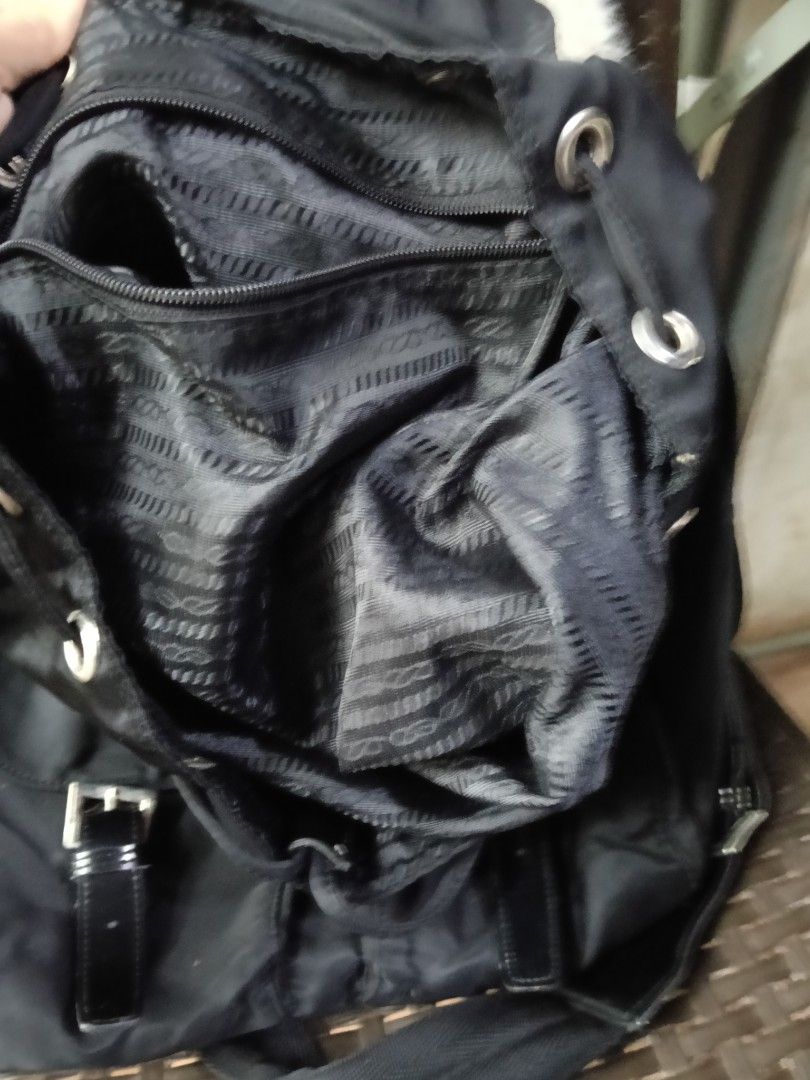 Prada Nylon Backpack Black (Category: Luxury Bags & Wallets) located in Antipolo. Submitted by vastgem_4c8da8 (Listing ID 1462884970, Image 2). Description: - Classic Prada backpack in black nylon - Iconic Prada triangle logo - Multiple front pockets with buckle closures - Drawstring and buckle flap closure - Interior zippered pocket - Great for everyday use or travel not sure kung OG .