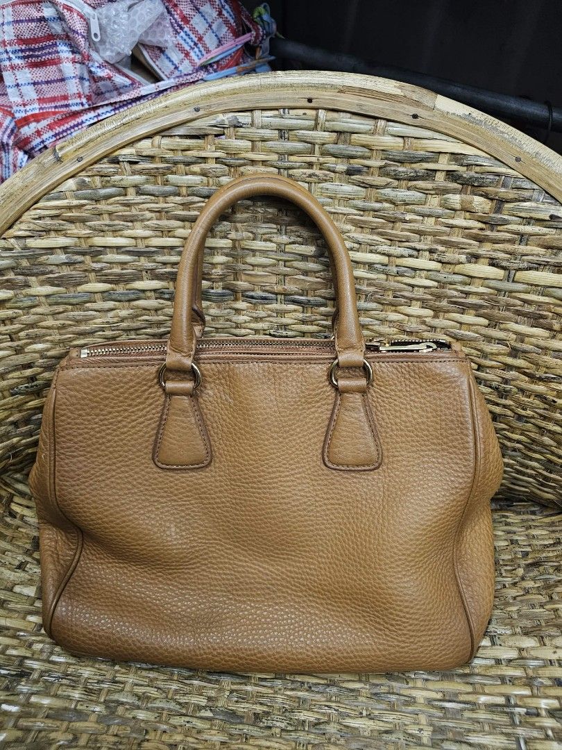 Prada Vitello (Category: Luxury Bags & Wallets) located in Bontoc. Submitted by athena_zia (Listing ID 1462846829, Image 2). Description: 🤎 PRADA Vitello Daino Top Handle Bag🤎 A timeless Prada classic in beautiful caramel brown grained leather, featuring the iconic Prada Milano logo, gold-tone hardware, and signature hanging tag. 🌸Condition: Good pre-loved condition 🌸 Normal signs of wear from previous use 🌸Few light rubs on the edges 🌸 Ove