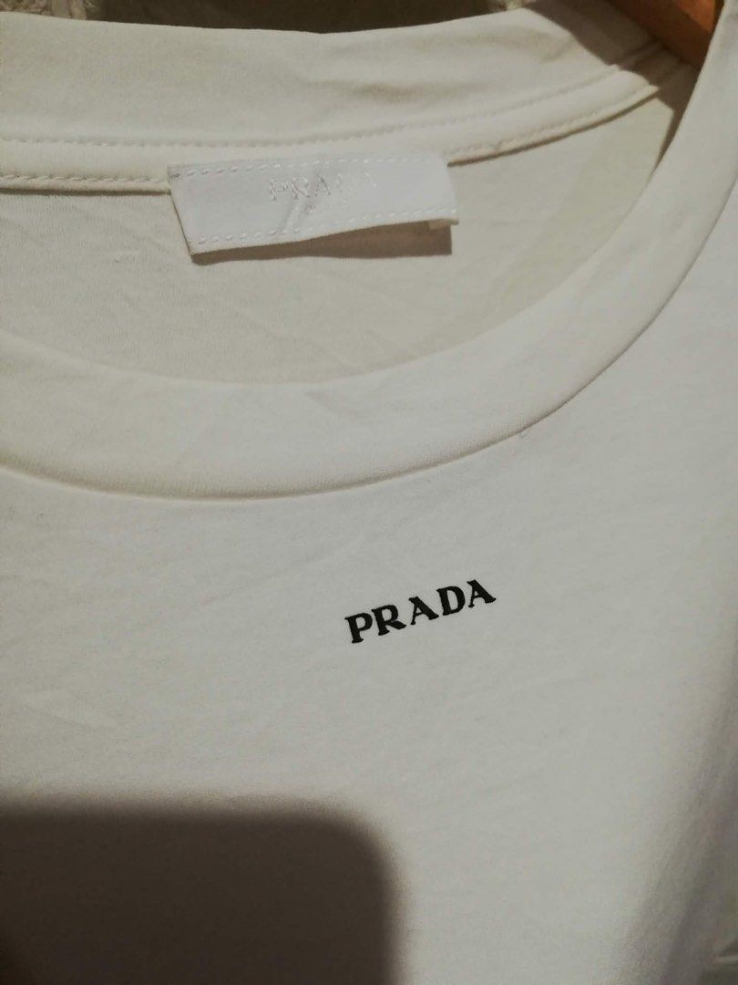 PRADA White T-Shirt (Category: Tshirts & Polo Shirts ) located in Rizal. Submitted by tiangarcia02 (Listing ID 1462830134, Image 2). Description: - Classic white Prada t-shirt - Features the iconic Prada logo on the chest - Tagged as size S - Comfortable and perfect for everyday casual wear.