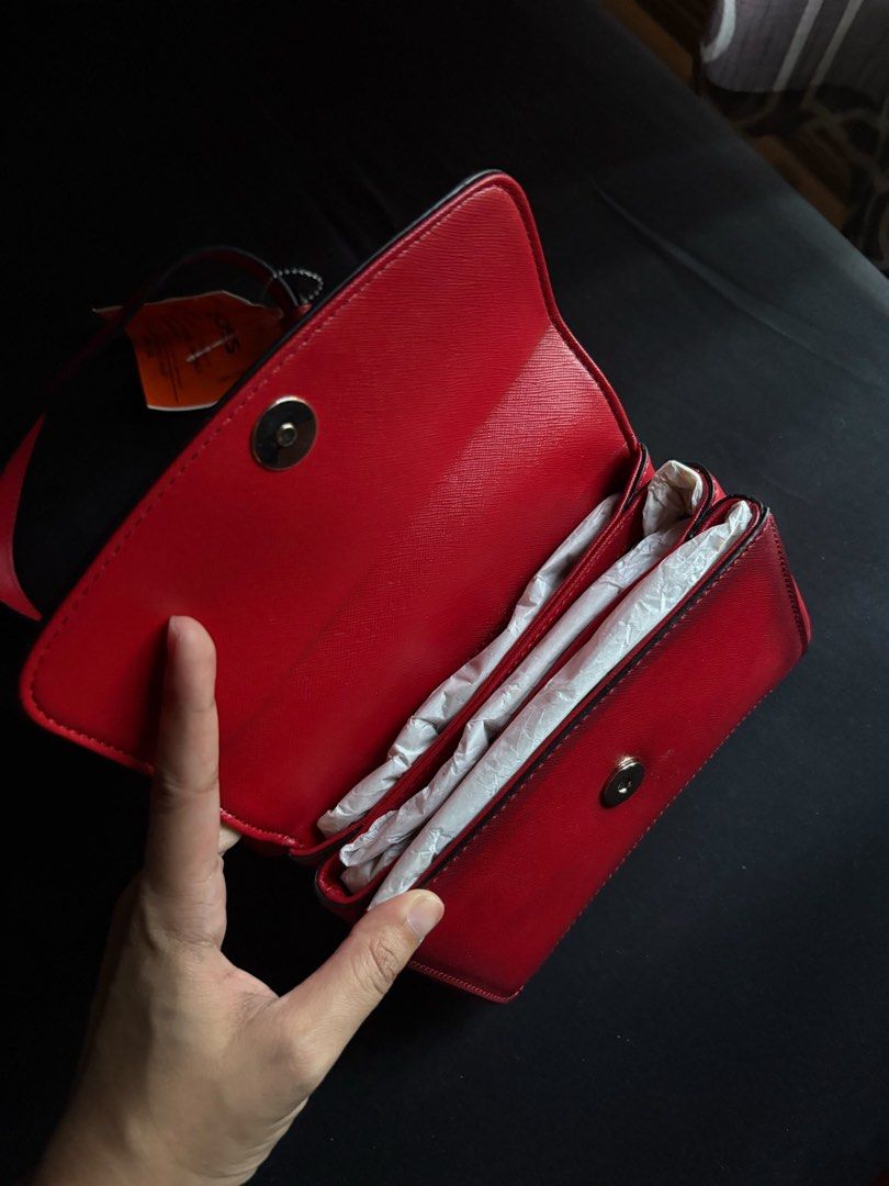Red DKNY Crossbody Bag (Category: Cross-body Bags) located in Calamba. Submitted by leeadriannn796 (Listing ID 1462708381, Image 3). Description: - Authentic DKNY crossbody bag - Color: Red - Material: Saffiano leather texture - Features: Gold DKNY logo on front, multiple interior compartments, adjustable strap - Condition: Brand new with original tag attached from Ross - Retail Value: $82.00.