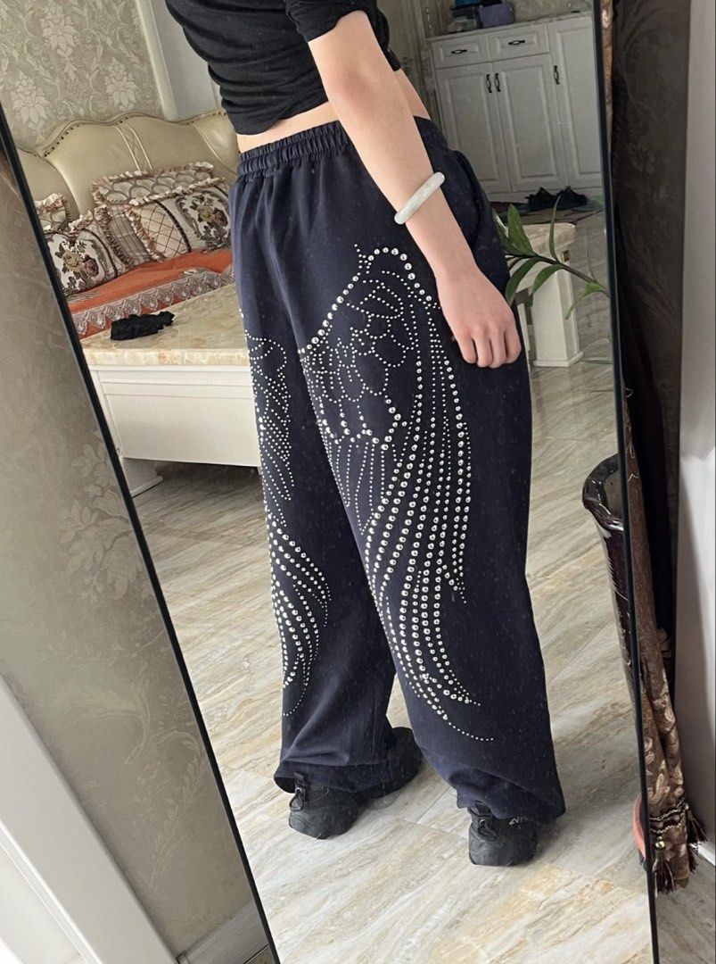 Rhinestone Wings Sweatpants (Category: Other Bottoms) located in San Fernando. Submitted by materialgirlxx (Listing ID 1462691963, Image 1). Description: - Cool dark blue sweatpants - Sparkly rhinestone wing design on the side - Elastic waistband with drawstring - Wide leg fit - Comfortable and stylish for casual wear or a statement outfit.