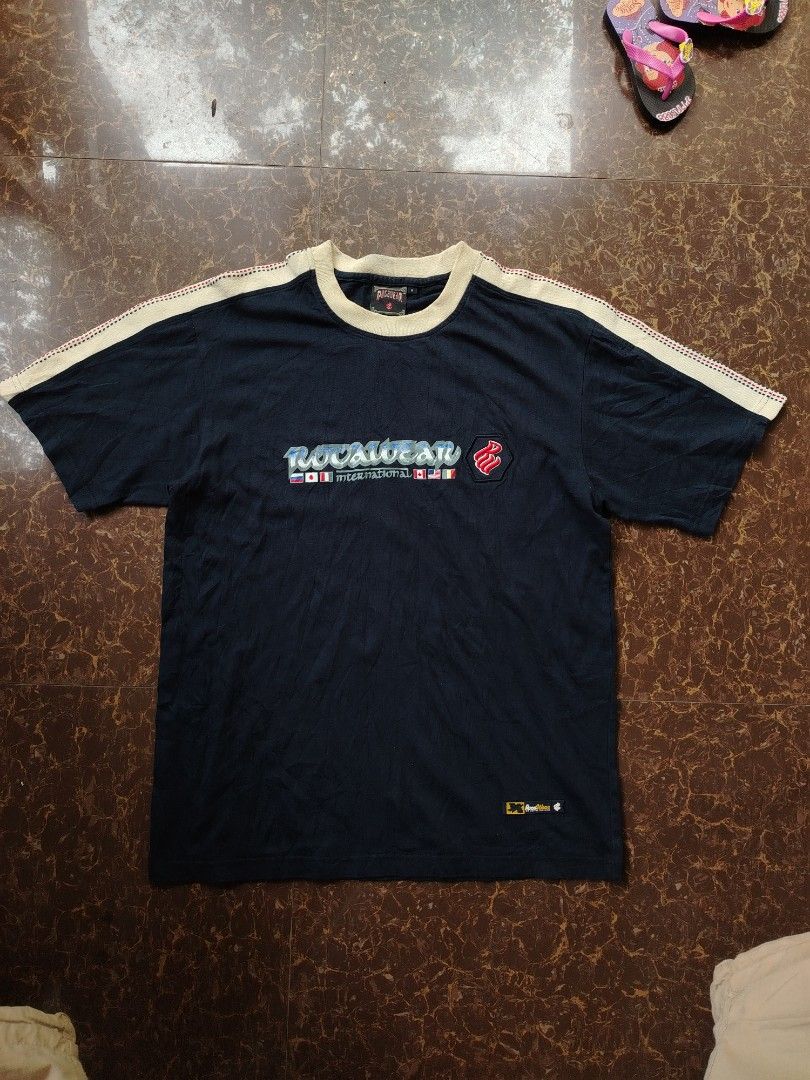 Rocawear International T-Shirt (Category: Tshirts & Polo Shirts ) located in Alegria. Submitted by goofy_ripper (Listing ID 1462760592, Image 1). Description: - Navy blue Rocawear t-shirt - Features 'Rocawear International' graphic with flags - Rocawear logo on the sleeve - Made of 100% cotton - Size: Medium (M) - Ideal for casual wear.