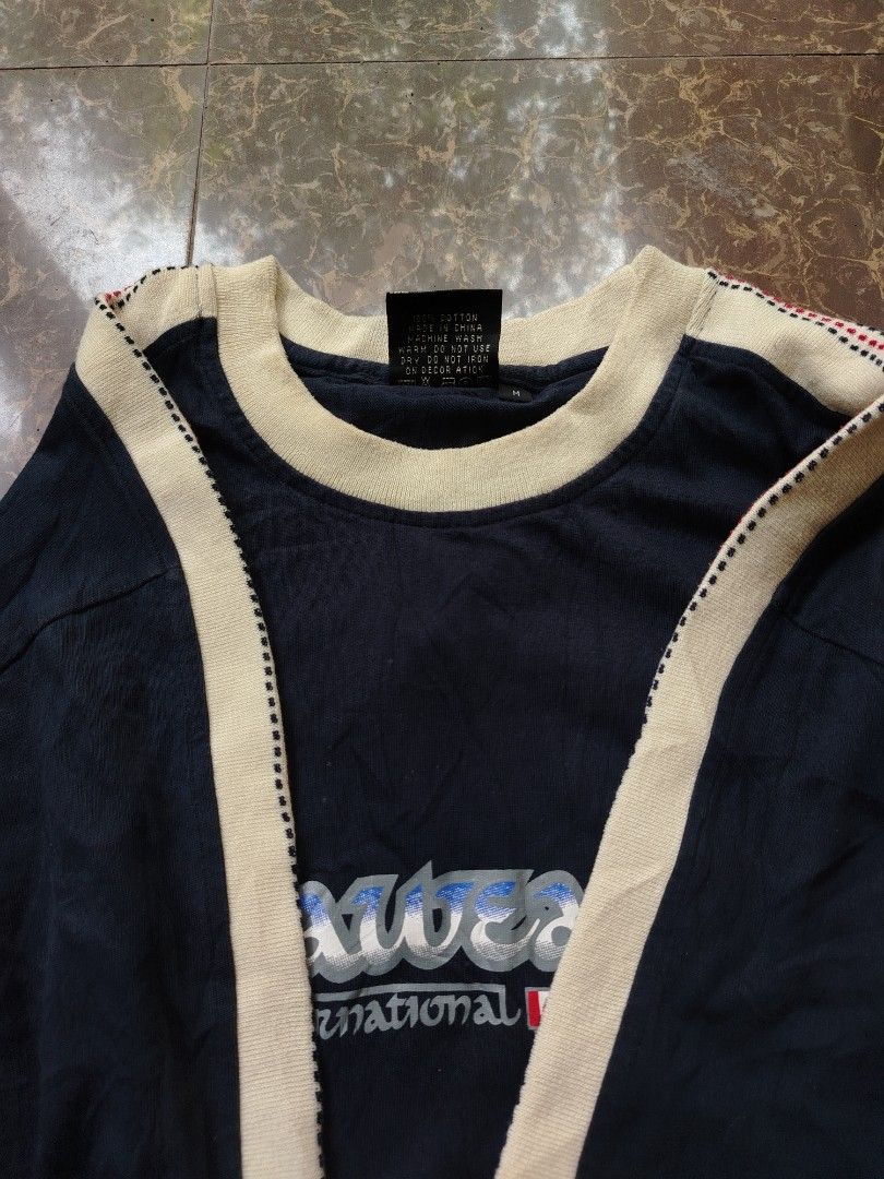 Rocawear International T-Shirt (Category: Tshirts & Polo Shirts ) located in Alegria. Submitted by goofy_ripper (Listing ID 1462760592, Image 3). Description: - Navy blue Rocawear t-shirt - Features 'Rocawear International' graphic with flags - Rocawear logo on the sleeve - Made of 100% cotton - Size: Medium (M) - Ideal for casual wear.
