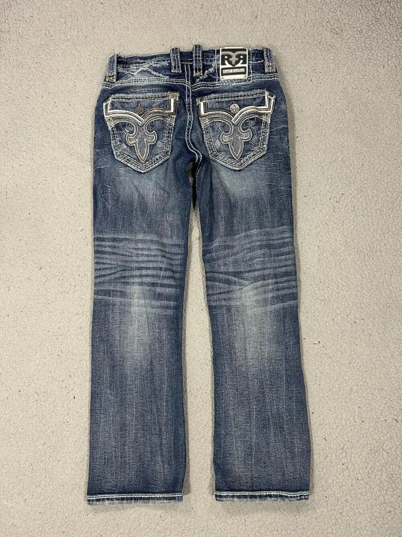 Rock Revival Jeans Distressed Blue Denim (Category: Jeans) located in Caloocan City. Submitted by thriftnigab2 (Listing ID 1462869122, Image 1). Description: - Rock Revival jeans - Distressed blue wash - White contrast stitching - Signature Rock Revival logo on back pockets - Rips and wear on front - Designed in USA, Made in Vietnam - Perfect for casual wear.