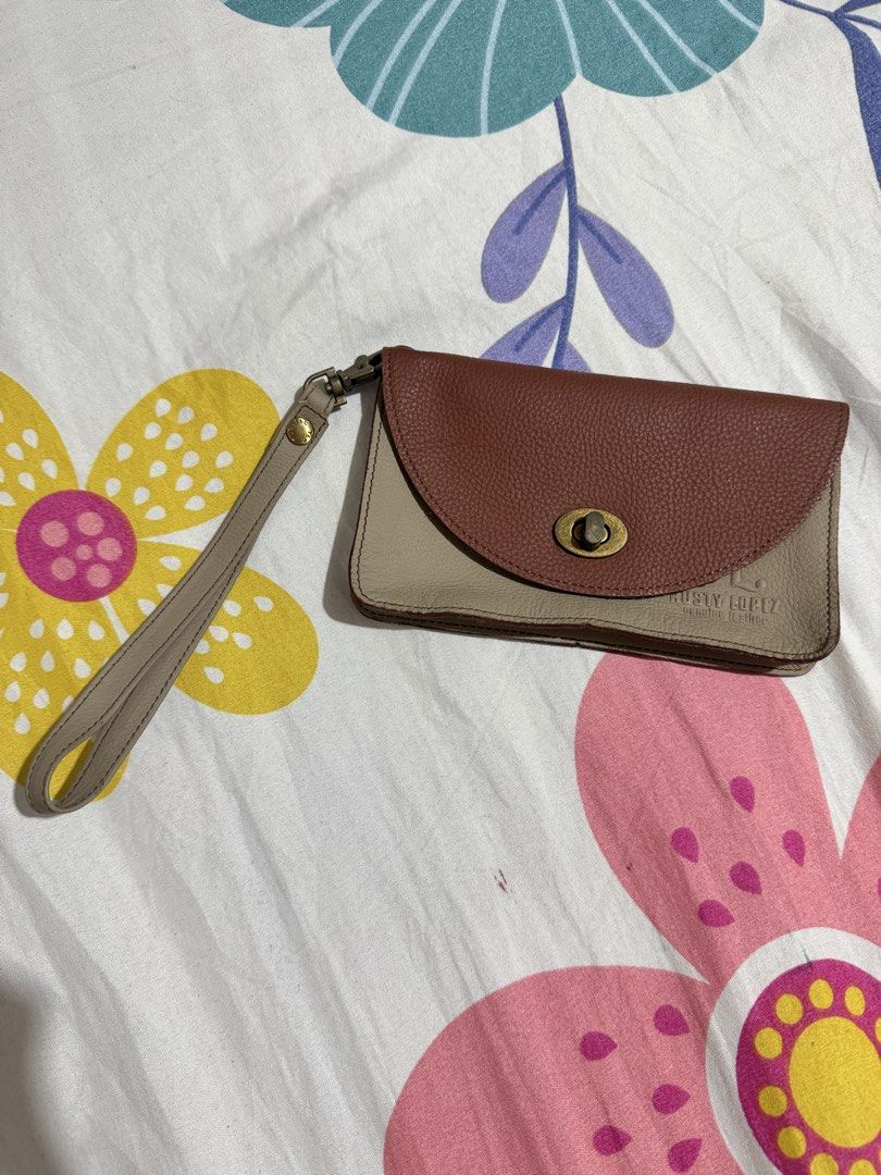 Rusty Lopez Genuine Leather Wristlet Wallet (Category: Wallets & Card holders) located in Manila. Submitted by chie04_875 (Listing ID 1462860683, Image 2). Description: - Genuine brown and beige leather wristlet - Secure twist lock closure - Detachable wrist strap for versatility - Spacious interior for cards and cash - Compact and stylish, ideal for quick errands or nights out.