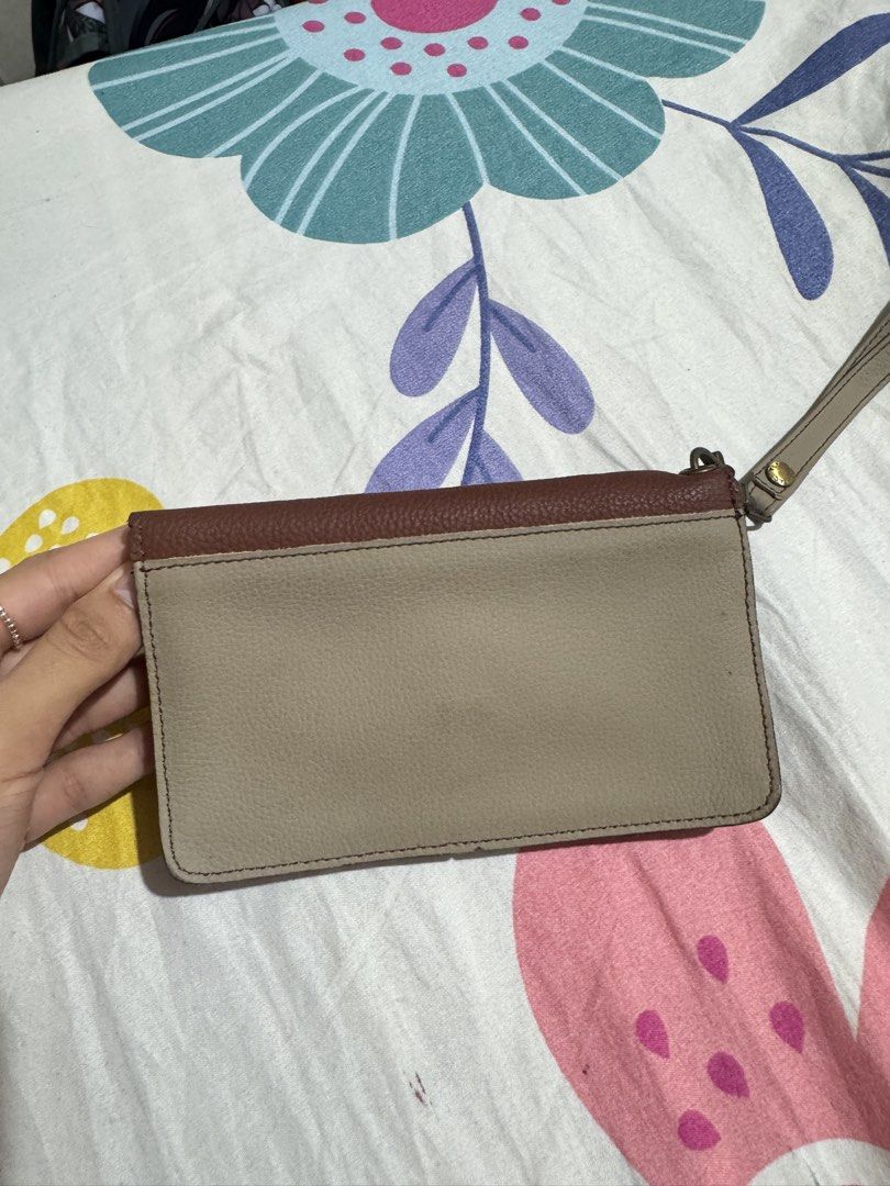 Rusty Lopez Genuine Leather Wristlet Wallet (Category: Wallets & Card holders) located in Manila. Submitted by chie04_875 (Listing ID 1462860683, Image 3). Description: - Genuine brown and beige leather wristlet - Secure twist lock closure - Detachable wrist strap for versatility - Spacious interior for cards and cash - Compact and stylish, ideal for quick errands or nights out.