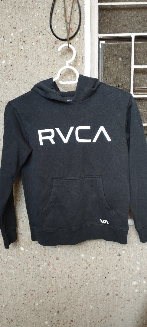 RVCA Black Hoodie (Category: Coats, Jackets and Outerwear) located in Manila. Submitted by beckster_nnline_luxuryshop (Listing ID 1462870709, Image 2). Description: - Black RVCA hoodie - Size: Medium (M) - White RVCA logo on the front - Small VA logo detail near the hem - Convenient kangaroo pocket - Adjustable drawstring hood - Made in Pakistan.