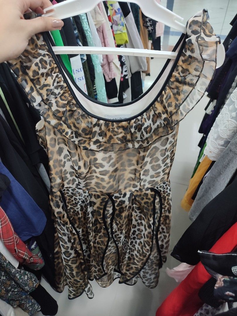 Sheer Leopard Print Ruffle Dress (Category: Dresses) located in Jaen. Submitted by roxantiago (Listing ID 1462696019, Image 1). Description: - Sheer leopard print fabric - Ruffle details on neckline and sleeves - Black trim along neckline and hem - Unique layered hem with black ribbon accents - Lightweight and flowy material - Perfect for night outs or stylish casual wear.