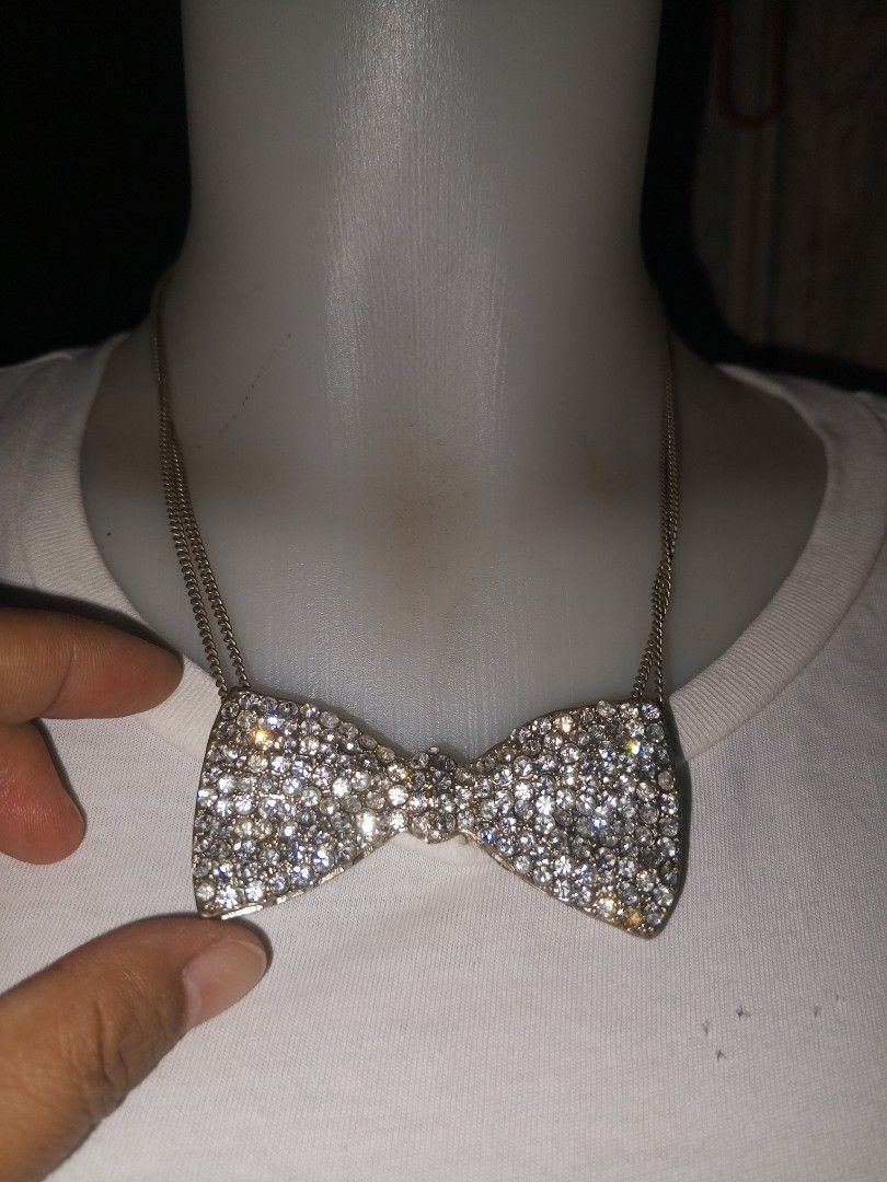 Sparkly Bowtie Pendant Necklace (Category: Necklaces) located in Magalang. Submitted by zeiansoria64090 (Listing ID 1462786513, Image 1). Description: - Super sparkly bowtie pendant covered in rhinestones. -japan accessories - Silver-toned chain. - Ideal accessory for parties or elevating any outfit. - Adds significant bling and glamour. - Chain length: Approximately X inches..