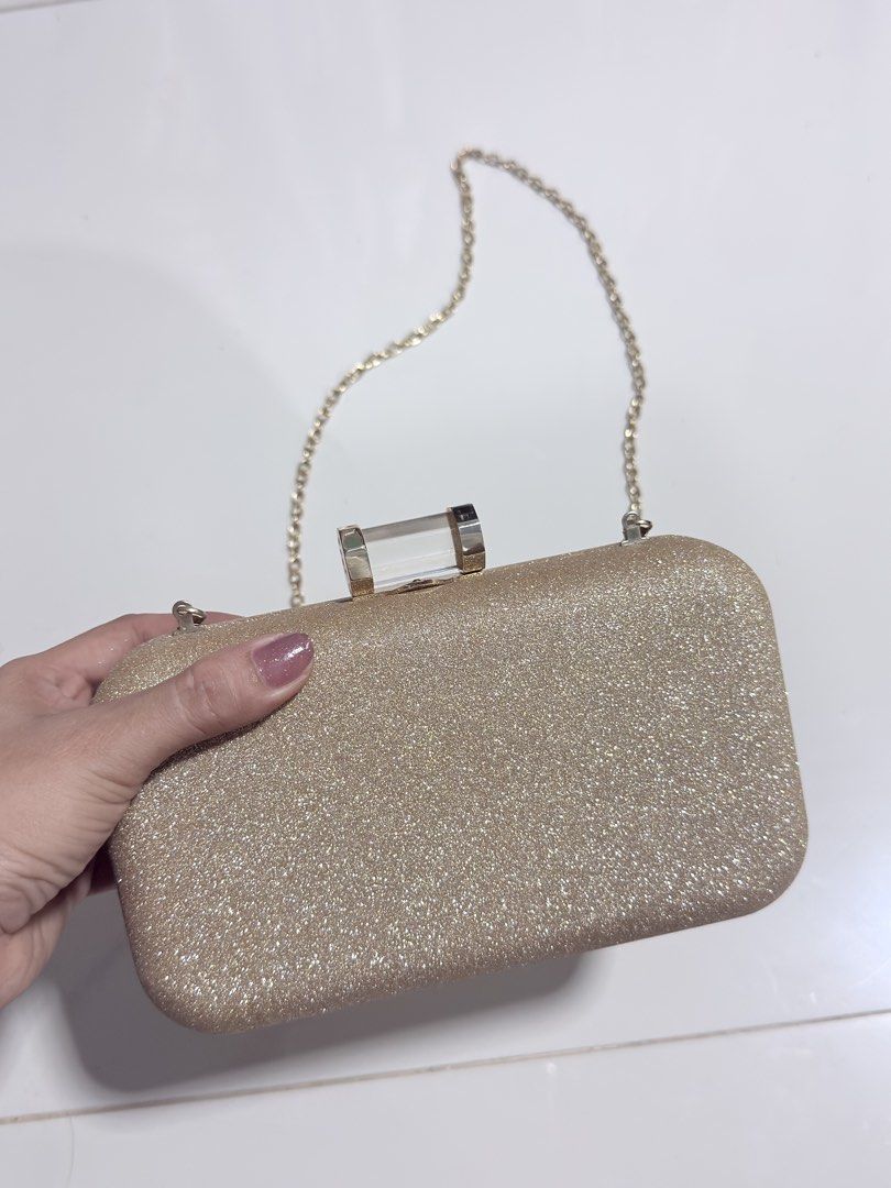 Sparkly Gold Clutch Bag with Chain Strap (Category: Clutches) located in Paranaque City. Submitted by thousandfold (Listing ID 1462690059, Image 3). Description: Sale or swap to catfood for strays 😊 or mofusand stuffed toy/tumblers - Stunning gold glitter clutch bag - Ideal for parties and special events - Detachable chain strap for versatility - Luxurious satin lining inside - Comes with a silica gel packet for preservation - Compact size: appr