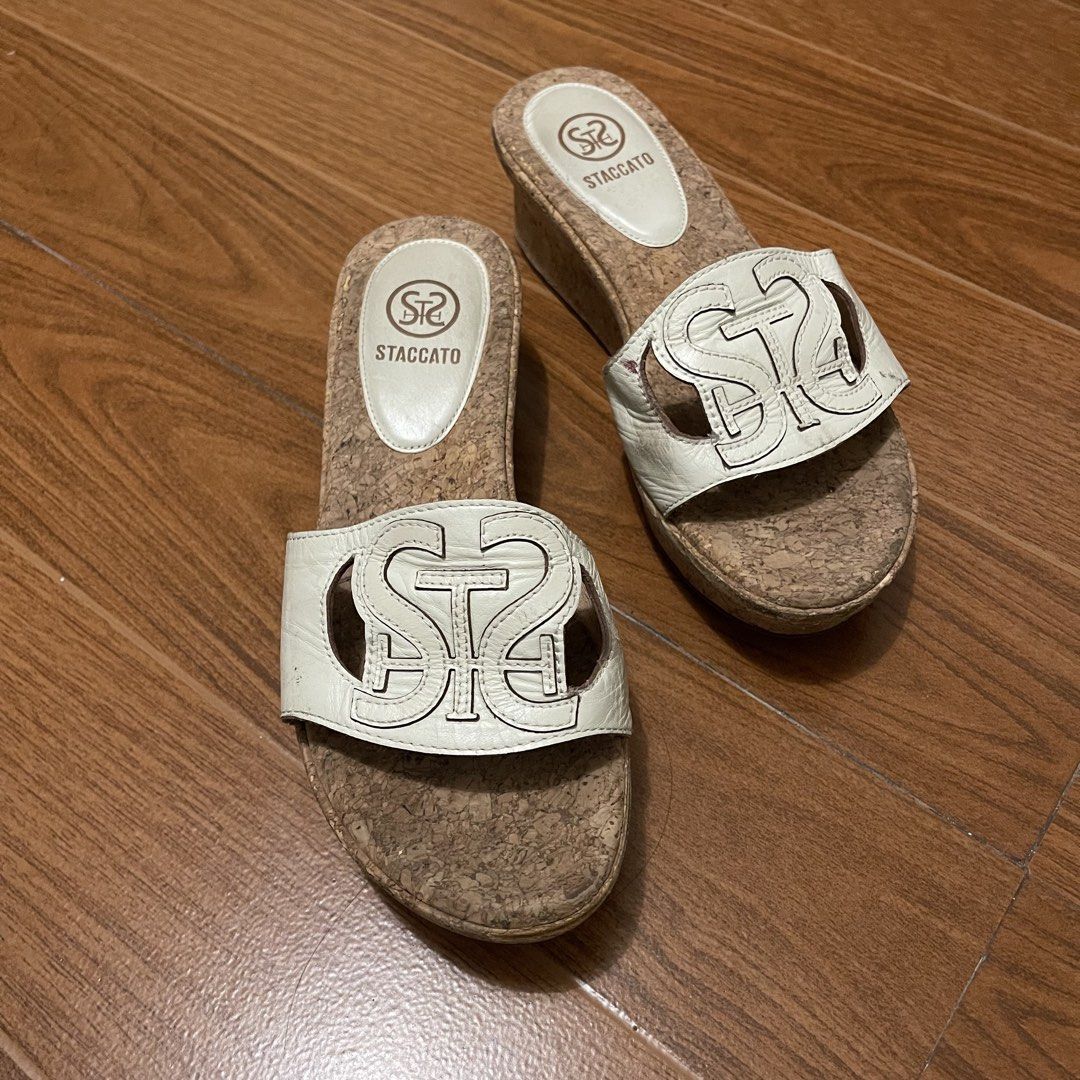 Staccato White Wedge Cork Sandals (Category: Wedges) located in Quezon City. Submitted by sahbee (Listing ID 1462833026, Image 1). Description: - White Staccato wedge sandals - Cork sole with white leather straps - Features Staccato logo on straps and insoles - Soles show some signs of wear - Ideal for casual wear - with signs of usage on the side of the wedge but not visible when worn. - original srp, 500 to 1k hkd..