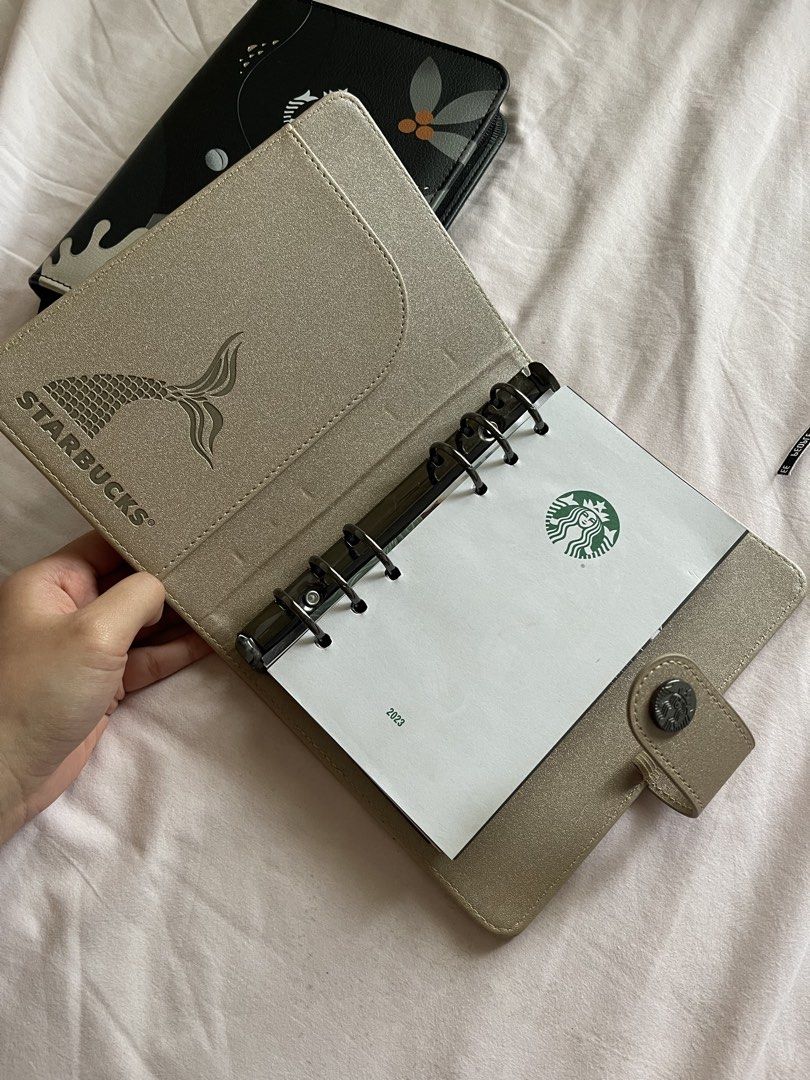 Starbucks Refillable Planner 2023 & 2026 (Category: Stationery & School Supplies) located in Balanga. Submitted by yenvalentino (Listing ID 1462754760, Image 3). Description: ‼️ READ DESCRIPTION BEFORE BUYING ‼️ Starbucks planners (2023 & 2026) BLACK (2026): Sleek zippered carrier case with a pen loop —DOES NOT INCLUDE THE PLANNER ITSELF CHAMPAGNE (2023): REFILLABLE The Ring-Binder Format: Notably deviated from traditional bound notebooks by feat