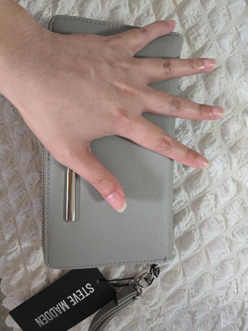 Steve Madden Wallet Wristlet (Category: Wallets & Card holders) located in Manila. Submitted by luxtimeless (Listing ID 1462787378, Image 2). Description: - Grey Steve Madden wallet - Zip-around closure - Detachable wrist strap - Multiple card slots - Clear ID window - Includes original tag.