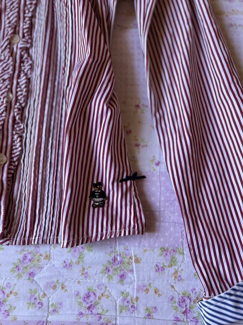 Striped Ruffle Button-Up Shirt (Category: Blouses) located in Cabanatuan. Submitted by j_preloved0012 (Listing ID 1462728673, Image 2). Description: - xs-m - Style: Button-up shirt - Color: Red and white stripes - Features: Ruffled front detail, button cuffs, cute bear logo on hem - Occasion: Great for casual or smart-casual wear.