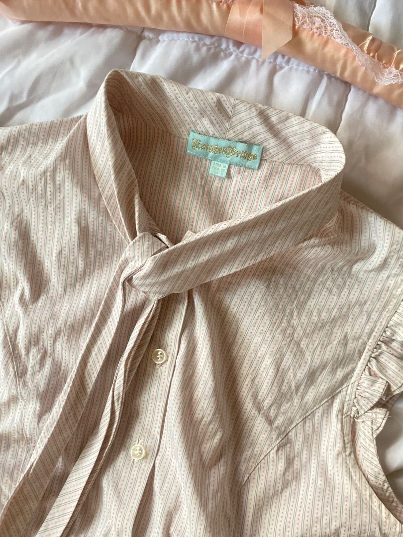 Striped Sleeveless Blouse with Tie Neck (Category: Blouses) located in Laoag. Submitted by shop.kawes (Listing ID 1462688546, Image 2). Description: - Light beige sleeveless blouse - Thin pinstripe pattern - Features a tie-neck detail - Ruffled cap sleeves - Button-up front - Versatile: looks great tucked into skirts or trousers - Classic wardrobe staple #y2k.
