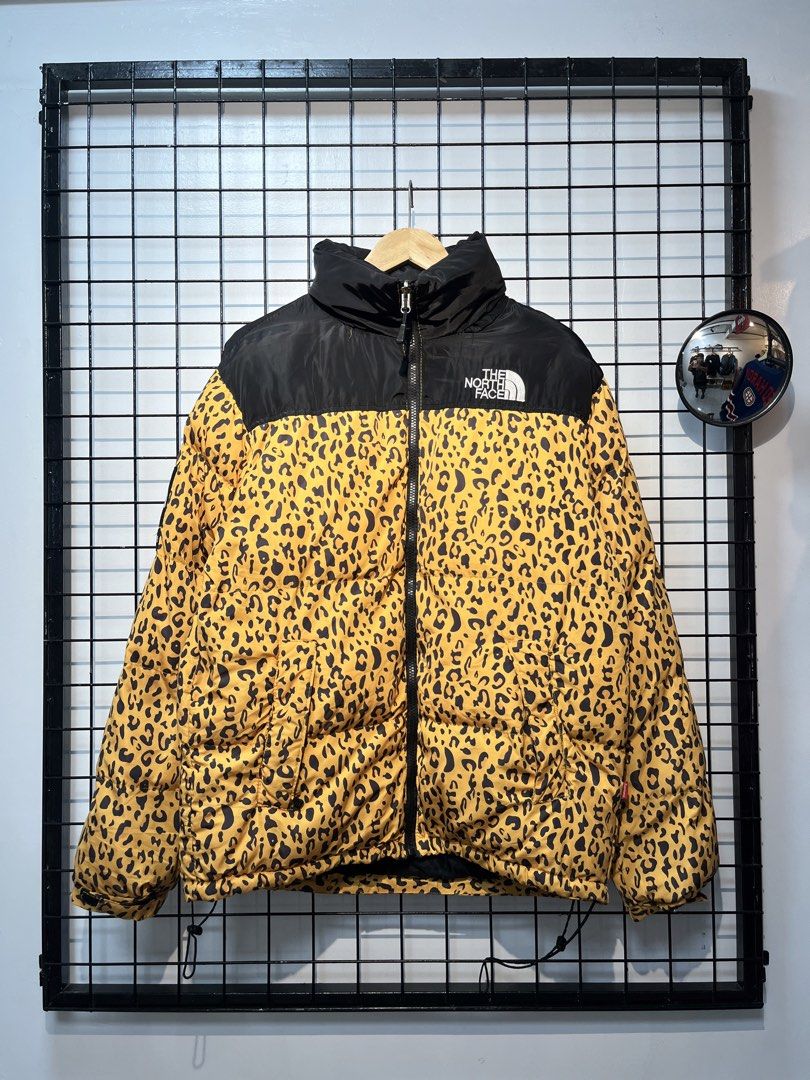 The North Face x Supreme Leopard Print Puffer Jacket (Category: Coats, Jackets and Outerwear) located in Taal. Submitted by thrift_deals23 (Listing ID 1462787630, Image 1). Description: - Supreme x The North Face Collaboration Puffer Jacket - Eye-catching Leopard Print with Black Accents - Full Zip Closure - Stand-Up Collar - Two Side Pockets - Adjustable Drawstring Hem - Size: Large (L) - Perfect for making a statement!.