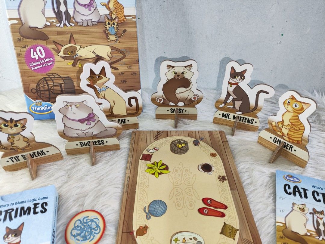 ThinkFun Cat Crimes Logic Game (Category: Board Games & Puzzles) located in Cavite. Submitted by tinetaclesss (Listing ID 1462696076, Image 3). Description: - ThinkFun Cat Crimes logic game - Includes: game board, 6 cat tokens with stands, 40 challenge cards - Perfect for solo play and developing problem-solving skills - Recommended for ages 8 to adult.