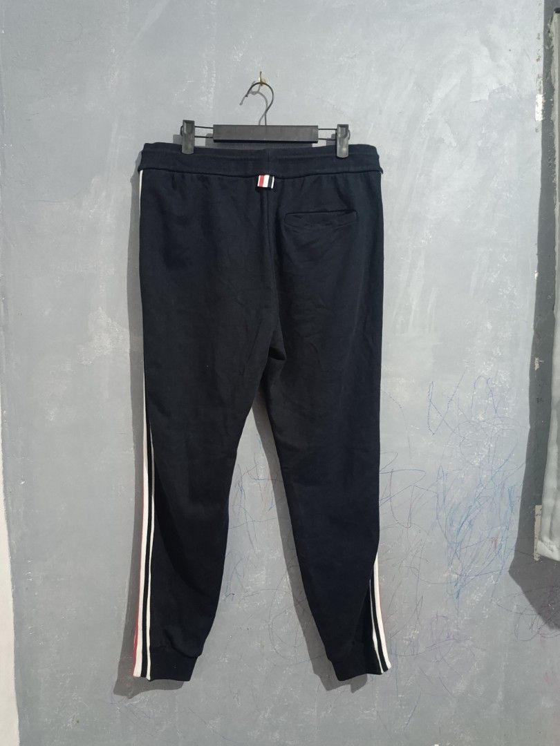 Thom Browne Navy Sweatpants with Tricolor Stripes (Category: Joggers) located in Iloilo. Submitted by wendxcz-thrift- (Listing ID 1462822392, Image 2). Description: - Thom Browne navy sweatpants - Features iconic tricolor stripes down the sides - Comfortable drawstring waist for adjustable fit - Expertly crafted in Japan - Ideal for stylish everyday wear MOP: GCASH/BPI + SF.