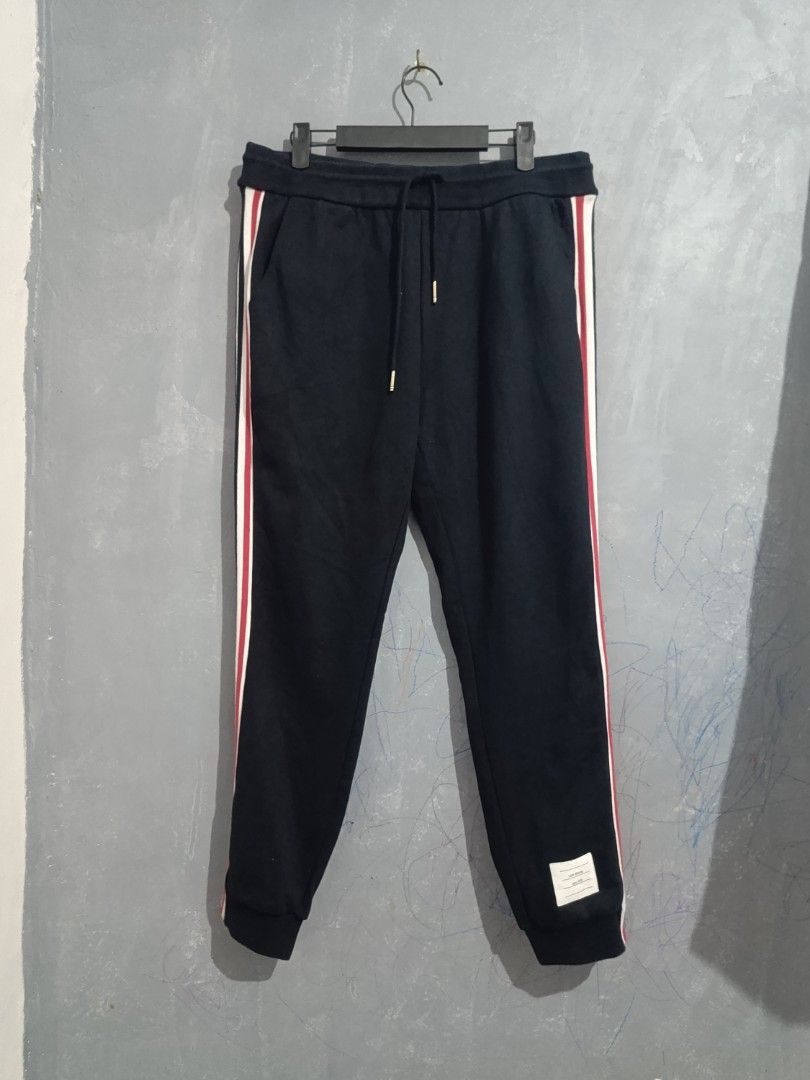 Thom Browne Navy Sweatpants with Tricolor Stripes (Category: Joggers) located in Iloilo. Submitted by wendxcz-thrift- (Listing ID 1462822392, Image 1). Description: - Thom Browne navy sweatpants - Features iconic tricolor stripes down the sides - Comfortable drawstring waist for adjustable fit - Expertly crafted in Japan - Ideal for stylish everyday wear MOP: GCASH/BPI + SF.