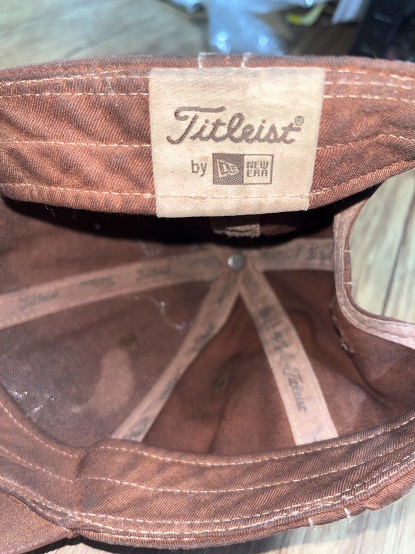 Titleist by New Era Brown Golf Cap (Category: Caps & Hats) located in San Pablo. Submitted by crazyr17 (Listing ID 1462845002, Image 2). Description: - Brand: Titleist (made by New Era) - Style: Classic baseball cap - Features: Stitching detail throughout, adjustable strap at the back - Ideal for: Golf or casual wear.