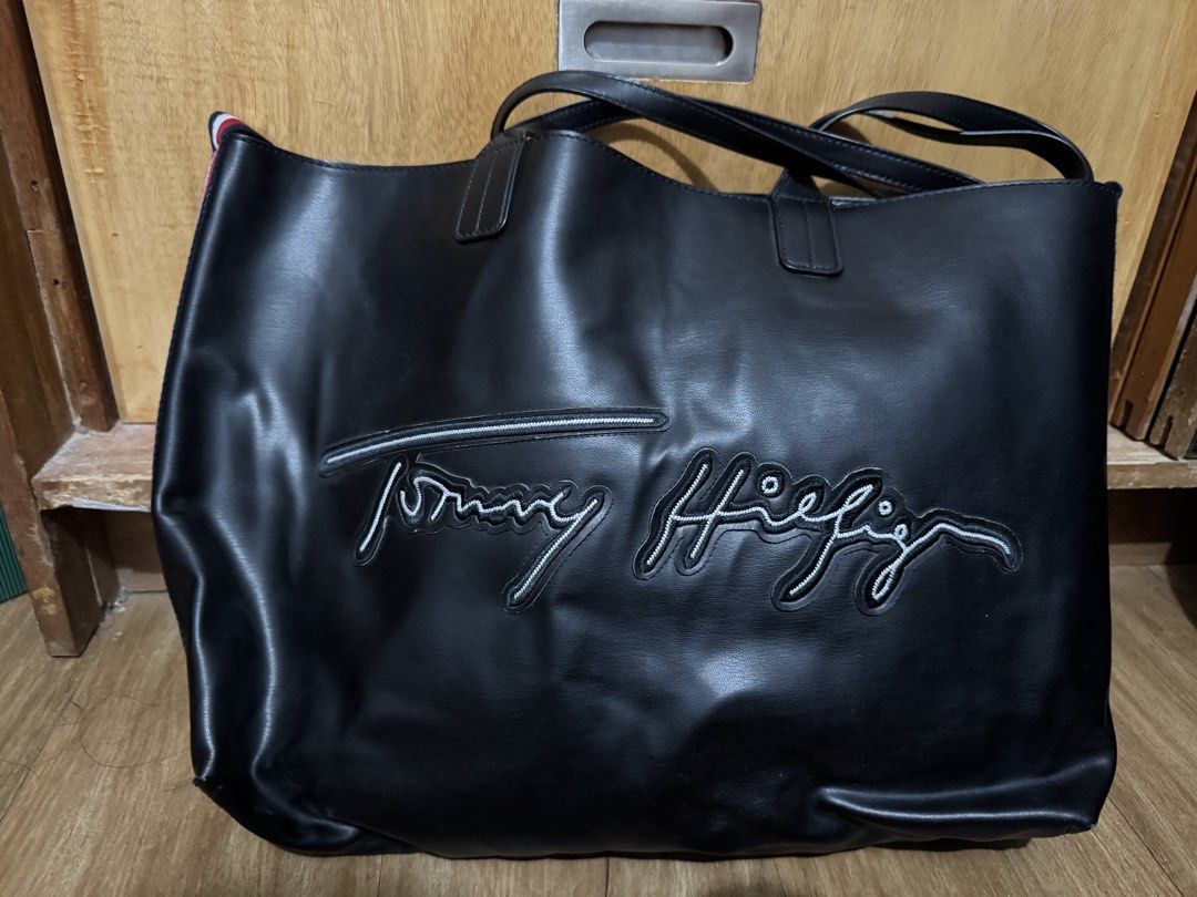 Tommy Hilfiger Black Tote Bag (Category: Tote Bags) located in Manila. Submitted by jrc1994 (Listing ID 1462868834, Image 2). Description: - Large black Tommy Hilfiger tote bag - Perfect for everyday use - Features embroidered signature Tommy Hilfiger logo on the front - Classic red, white, and blue stripe detail on the sides - Handles show some signs of wear -RSF decluttering -LP l000.