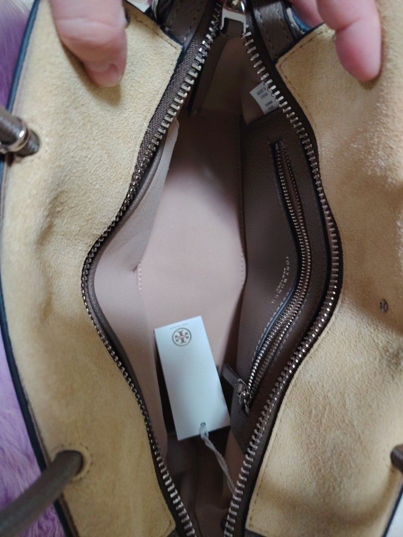 Tory Burch Leather Tote Bag (Category: Luxury Bags & Wallets) located in Valenzuela. Submitted by glitter_preloved (Listing ID 1462791444, Image 3). Description: - Authentic Tory Burch tote bag - Color: Taupe - Material: Genuine leather exterior, suede interior - Features: Detachable shoulder strap, interior zippered pockets - Condition: Brand new with original tags - Ideal for: Everyday use.