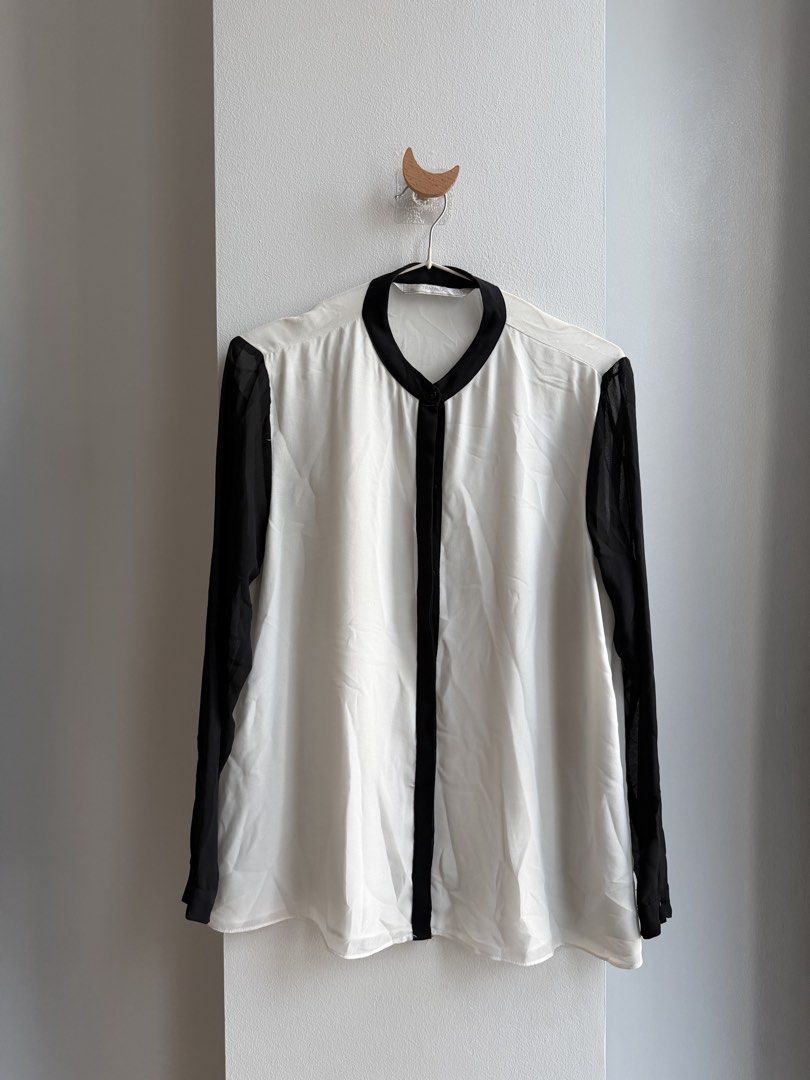 TRAFALUC White Black Long Sleeve Blouse (Category: Blouses) located in Makati City. Submitted by ariannelaz54133 (Listing ID 1462836022, Image 1). Description: - White blouse with elegant black sheer sleeves. - Features black trim around the collar and down the front. - Convenient button closure at the neck. - Simple and classic design, perfect for dressing up or down..