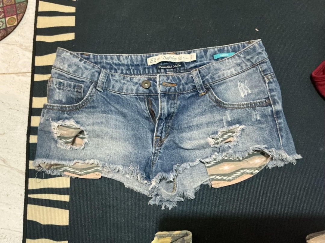 TRAFALUC Zara Denim Shorts (Category: Shorts) located in Quezon City. Submitted by nicskulasa (Listing ID 1462812336, Image 1). Description: - Brand: TRAFALUC by Zara - Type: Blue Denim Shorts - Size: EUR 36 - Style: Distressed with rips and frayed hem - Unique Feature: Patterned fabric peeking through rips - Closure: Button and zip.