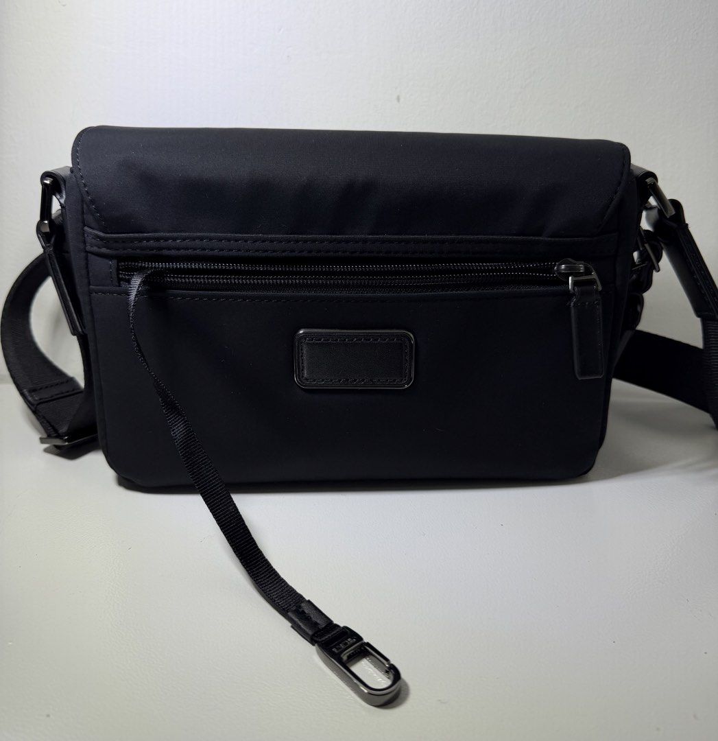 Tumi Harrison Parson Men’s Crossbody Bag (Category: Sling Bags) located in Manila. Submitted by importgoodiesph (Listing ID 1462826104, Image 3). Description: Tumi Harrison Parson Men’s Crossbody Bag - in excellent condition - dimensions: 8.25cm × 23cm × 16.5cm - primary material: nylon (some leather accents) - color: black - Exterior: • flap entry with speed clip • adjustable crossbody strap with leather accents • gusseted zip pocket • back zip 