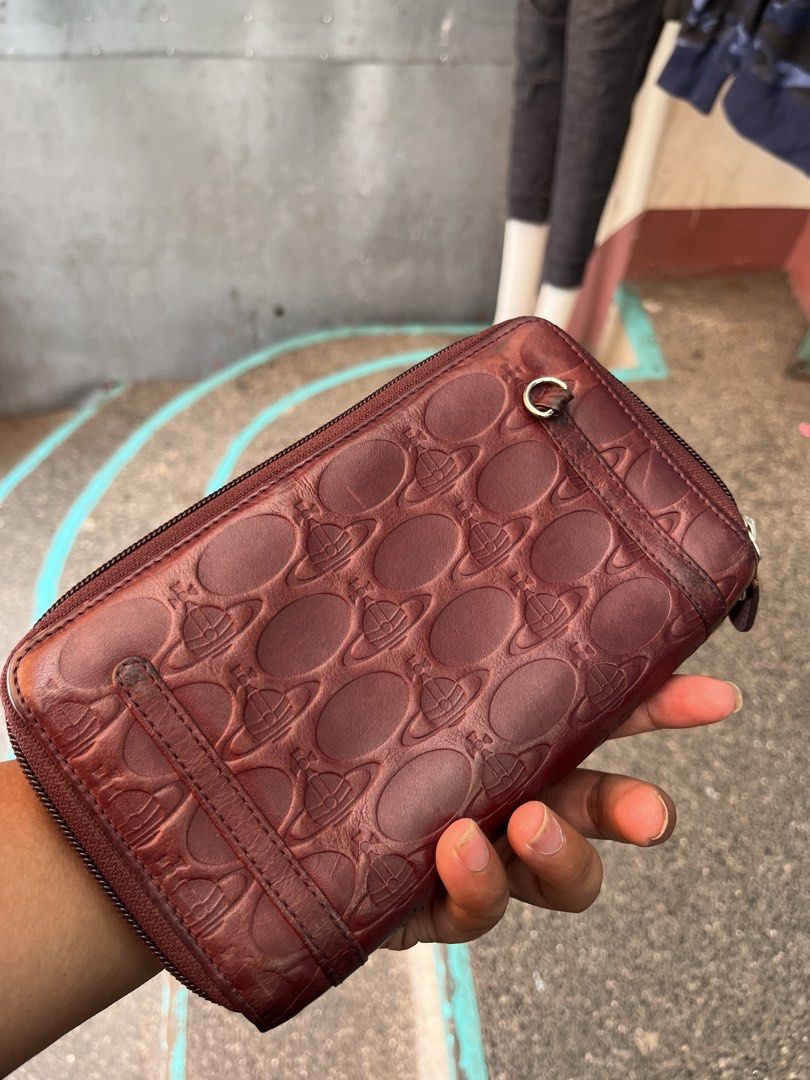 Vivienne Westwood Leather Orb Pattern Zip Around Wallet (Category: Luxury Bags & Wallets) located in Tabuk. Submitted by collectors_thrift_shop (Listing ID 1462706469, Image 2). Description: - Authentic Vivienne Westwood wallet - Genuine leather with iconic orb pattern - Zip-around closure for security - Multiple card slots and compartments for organization - Made in Italy - Shows some signs of wear on interior and exterior, consistent with regul