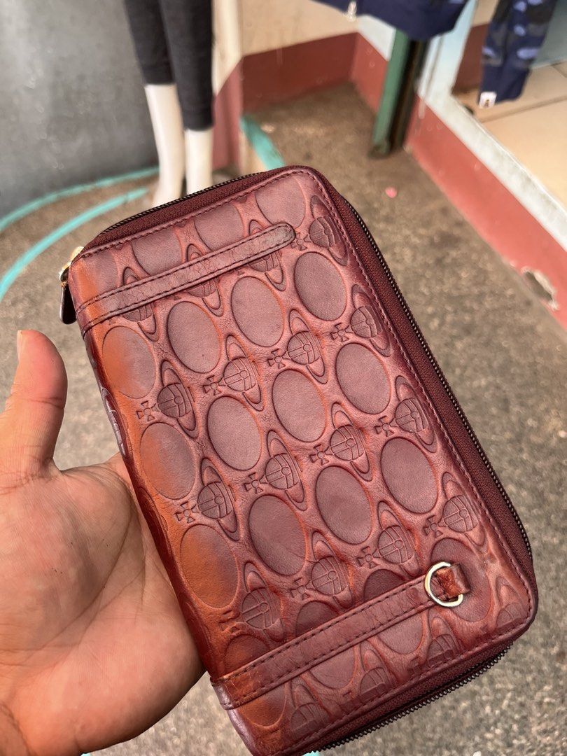 Vivienne Westwood Leather Orb Pattern Zip Around Wallet (Category: Luxury Bags & Wallets) located in Tabuk. Submitted by collectors_thrift_shop (Listing ID 1462706469, Image 1). Description: - Authentic Vivienne Westwood wallet - Genuine leather with iconic orb pattern - Zip-around closure for security - Multiple card slots and compartments for organization - Made in Italy - Shows some signs of wear on interior and exterior, consistent with regul