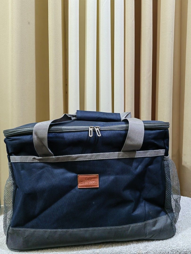 Weyoung Navy Blue Insulated Cooler Bag (Category: Food Organization & Storage) located in Makati City. Submitted by prelovedtreatedwithlove (Listing ID 1462847847, Image 1). Description: - Navy blue Weyoung cooler bag - Spacious main compartment with insulated lining - Two mesh side pockets for extra storage - Sturdy handles and zip closure - Ideal for picnics, beach trips, or keeping food cool on the go. - Big size 40x27x27cm -with strap -like n