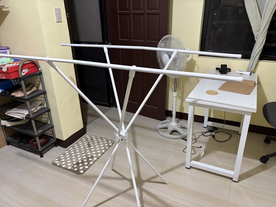 White Foldable Drying Rack for Clothes (Category: Clothes Drying Rack) located in Makati City. Submitted by ria_cat (Listing ID 1462868519, Image 1). Description: - White foldable drying rack - Multiple bars for hanging clothes - Ideal for indoor or outdoor laundry drying - Simple to set up and store away - Sturdy and reliable design.