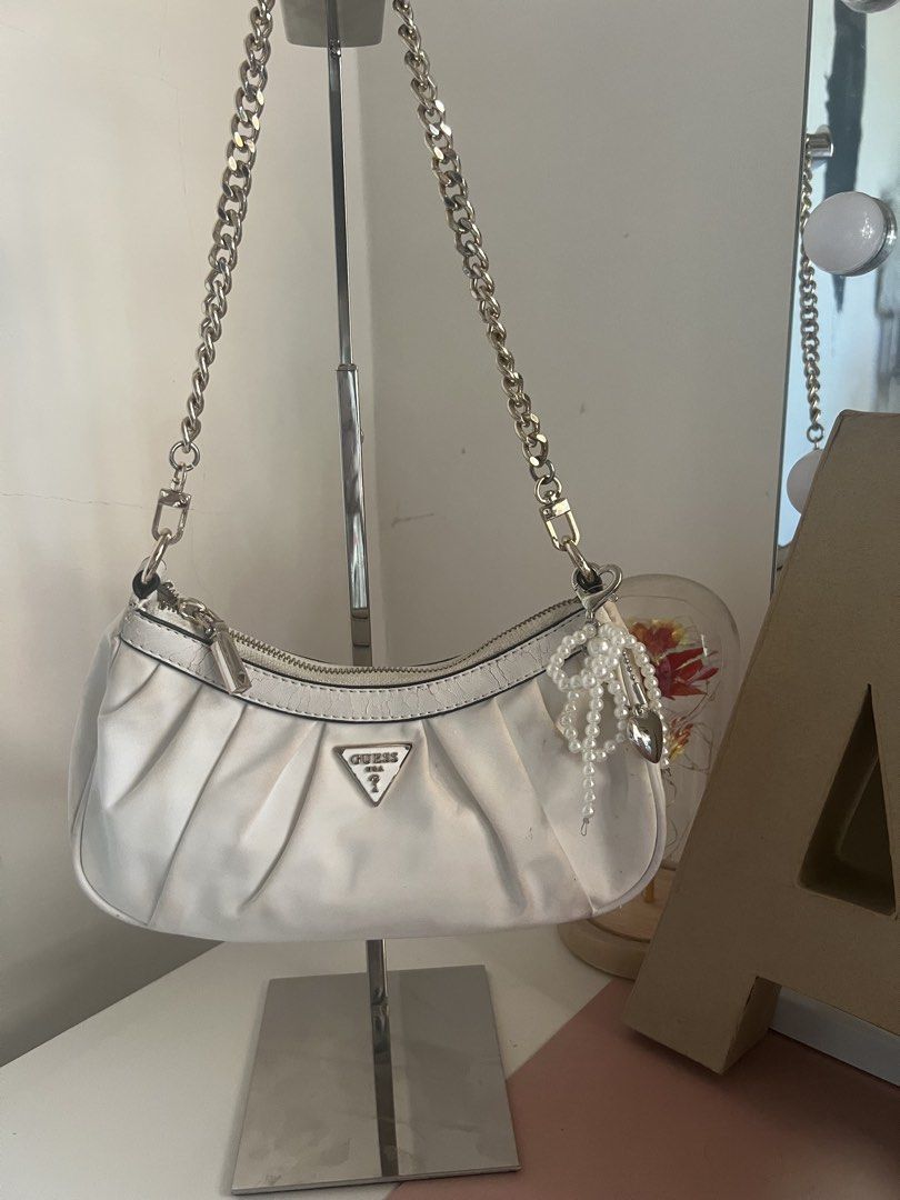 White GUESS Ruched Shoulder Bag (Category: Shoulder Bags) located in Bulacan. Submitted by shopwithaaz (Listing ID 1462765733, Image 1). Description: - GUESS white ruched shoulder bag - Silver chain strap - heart charm NOT included - Secure zipper closure - Minor marks on fabric (please check photos for details) - Ideal for casual outings and everyday use.
