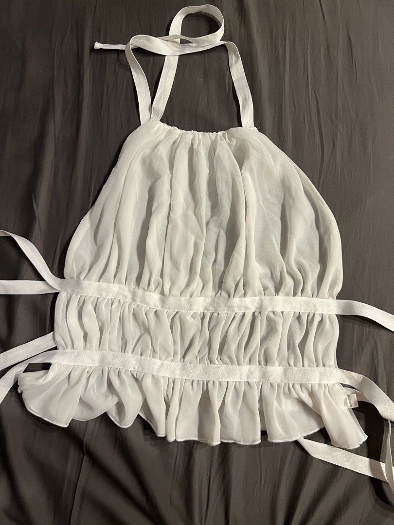 White Sheer Halter Neck Top with Ruffles (Category: Sleeveless) located in Paranaque City. Submitted by dubaichocolei (Listing ID 1462739911, Image 1). Description: - White sheer halter neck top - Features ruffles along hem and bust - Ties at back and neck for adjustable fit - Lightweight and flowy material - Perfect for layering or wearing solo.