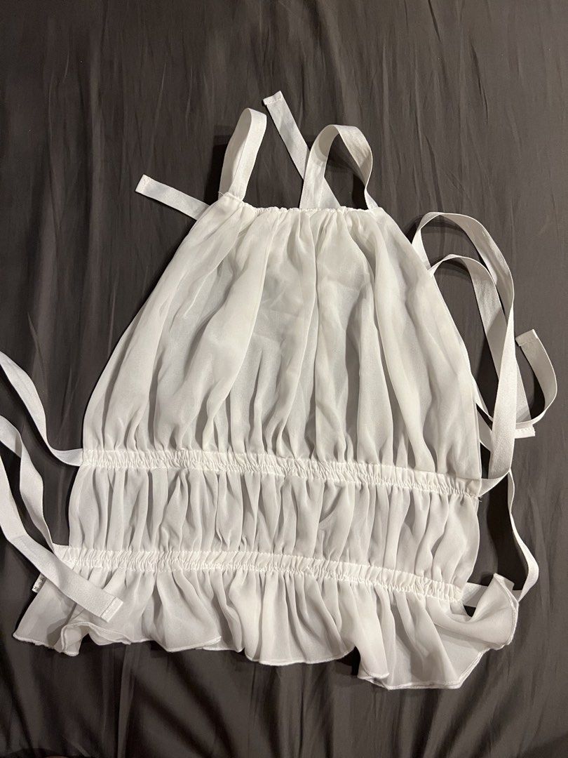 White Sheer Halter Neck Top with Ruffles (Category: Sleeveless) located in Paranaque City. Submitted by dubaichocolei (Listing ID 1462739911, Image 2). Description: - White sheer halter neck top - Features ruffles along hem and bust - Ties at back and neck for adjustable fit - Lightweight and flowy material - Perfect for layering or wearing solo.