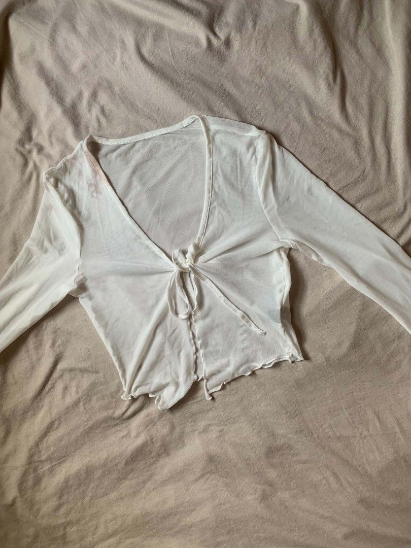 White sheer tie-front long sleeve (SHEIN top) (Category: Longsleeves) located in Cebu City. Submitted by book_bird (Listing ID 1462763381, Image 1). Description: - Sheer white mesh fabric - Long sleeves - Tie-front closure at the bust - Lettuce hem detail - Lightweight and airy - Ideal for layering over bralettes or camis.