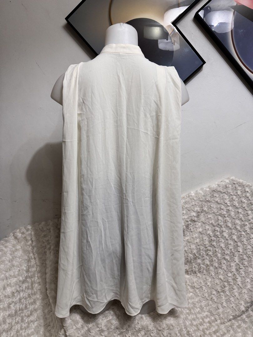 White Sleeveless Mandarin Collar Button-Up Top (Category: Sleeveless) located in Marikina City. Submitted by lorradel (Listing ID 1462716979, Image 3). Description: - White sleeveless top - Mandarin collar - Full front button closure - Flowy, drapey fabric - Versatile for layering or wearing solo - Timeless, classic elegant design - MAY HAVE some washable stains (hindi maiiwasan) needs washing; had been stored - mannequin size 34-26-34 - mannequi