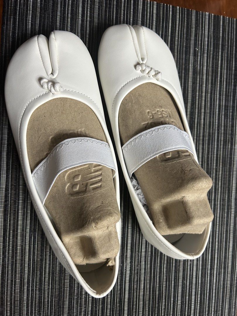 White Tabi Split Toe Ballet Flats with Elastic Strap (Category: Flats & Sandals) located in Manila. Submitted by dubichachi (Listing ID 1462735748, Image 1). Description: - White tabi flats with a unique split toe design. - Elastic strap across the instep ensures a secure and comfortable fit. - Simple and clean aesthetic, versatile for any outfit. - Textured sole provides excellent grip for everyday wear. - Marked as Size 7 on the sole..
